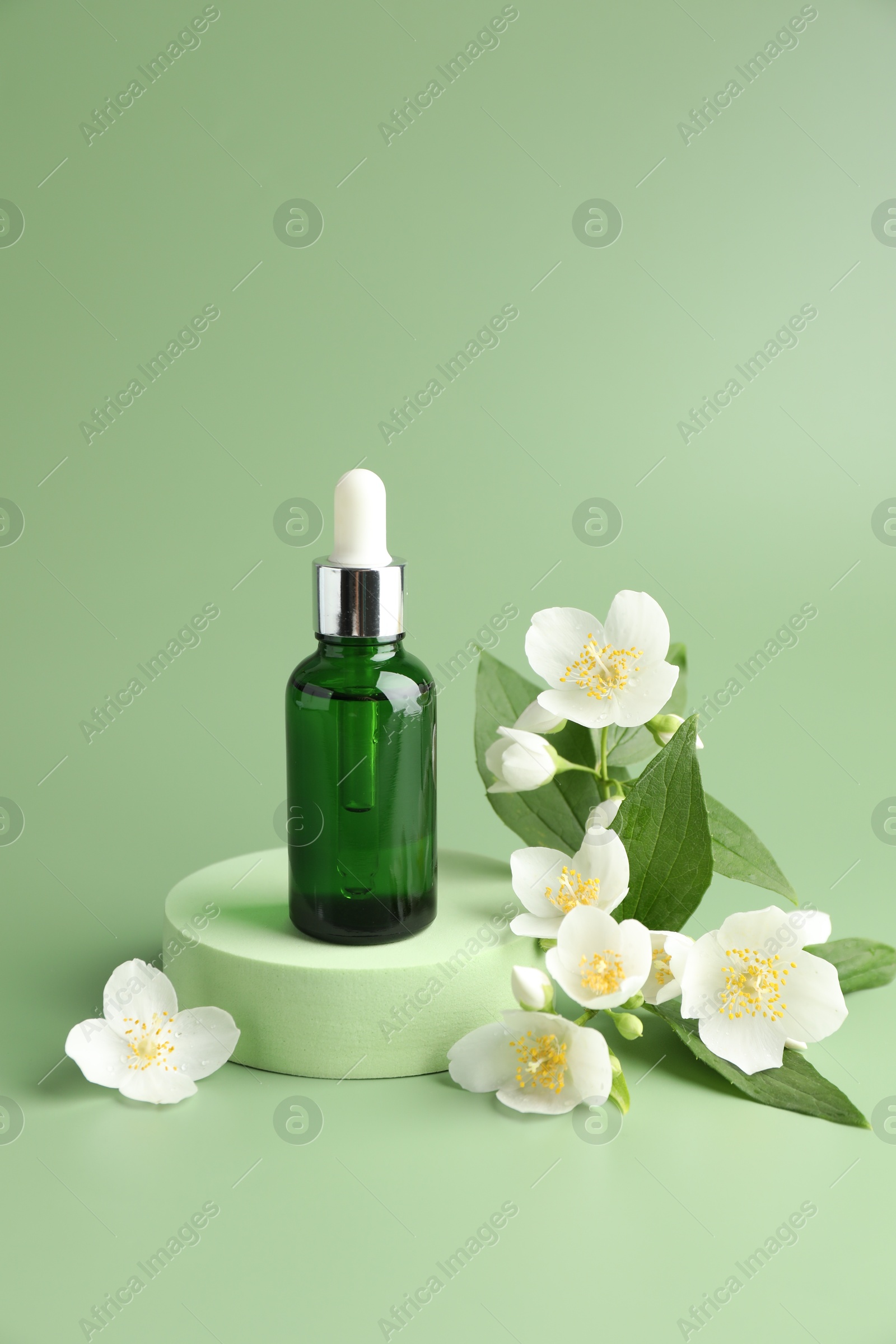 Cosmetic product and jasmine flowers on green background Photo of Cosmetic product and jasmine flowers on green background