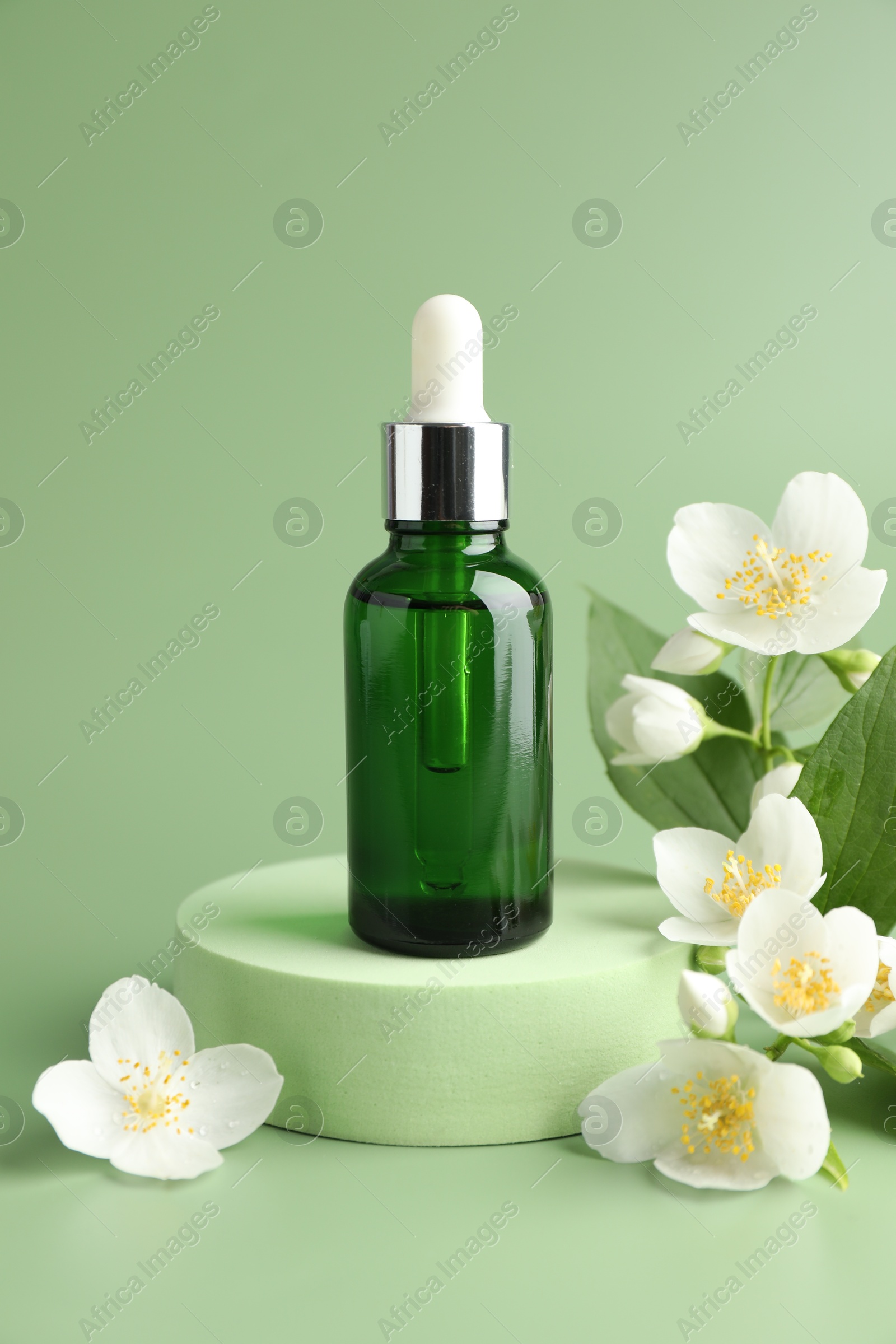 Cosmetic product and jasmine flowers on green background Photo of Cosmetic product and jasmine flowers on green background