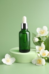 Photo of Cosmetic product and jasmine flowers on green background
