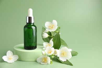 Photo of Cosmetic product and jasmine flowers on green background. Space for text