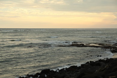 Photo of Many stones on beach near wavy sea