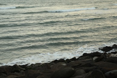 Photo of Many stones on beach near wavy sea