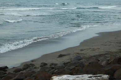Photo of View of beautiful wavy sea and rocky beach
