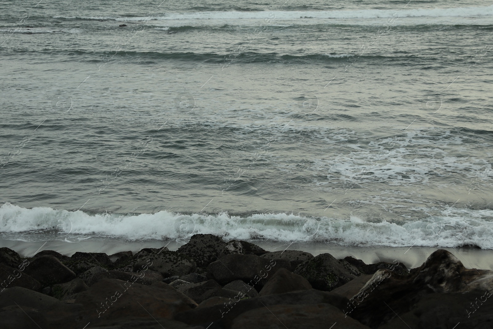 View of beautiful wavy sea and rocky beach Photo of View of beautiful wavy sea and rocky beach