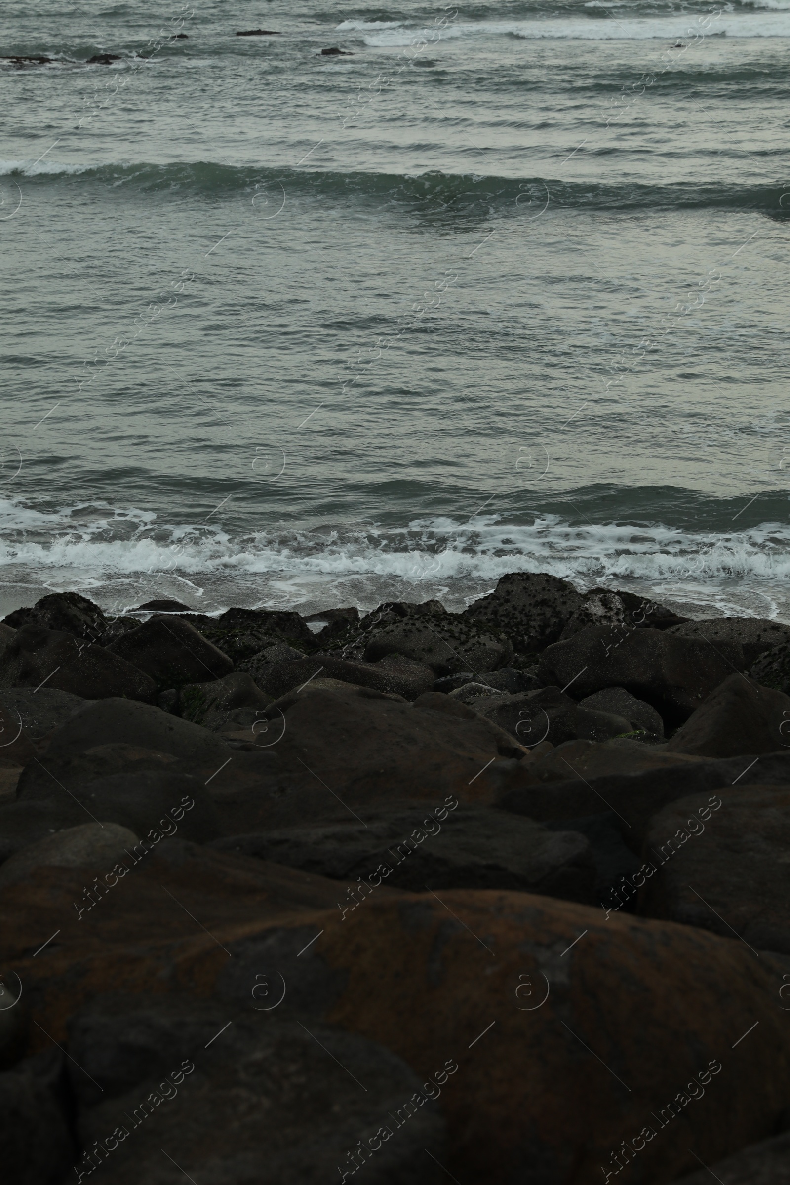 View of beautiful wavy sea and many stones, closeup Photo of View of beautiful wavy sea and many stones, closeup