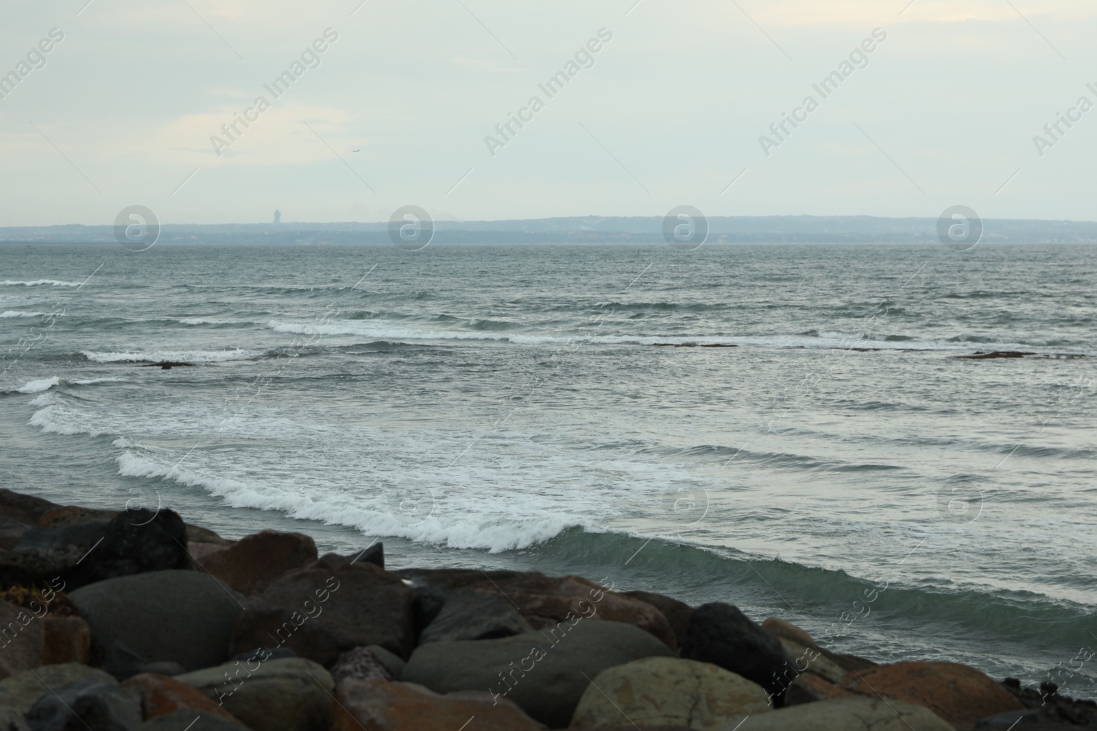 View of beautiful wavy sea and rocky beach Photo of View of beautiful wavy sea and rocky beach
