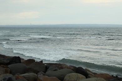 Photo of View of beautiful wavy sea and rocky beach