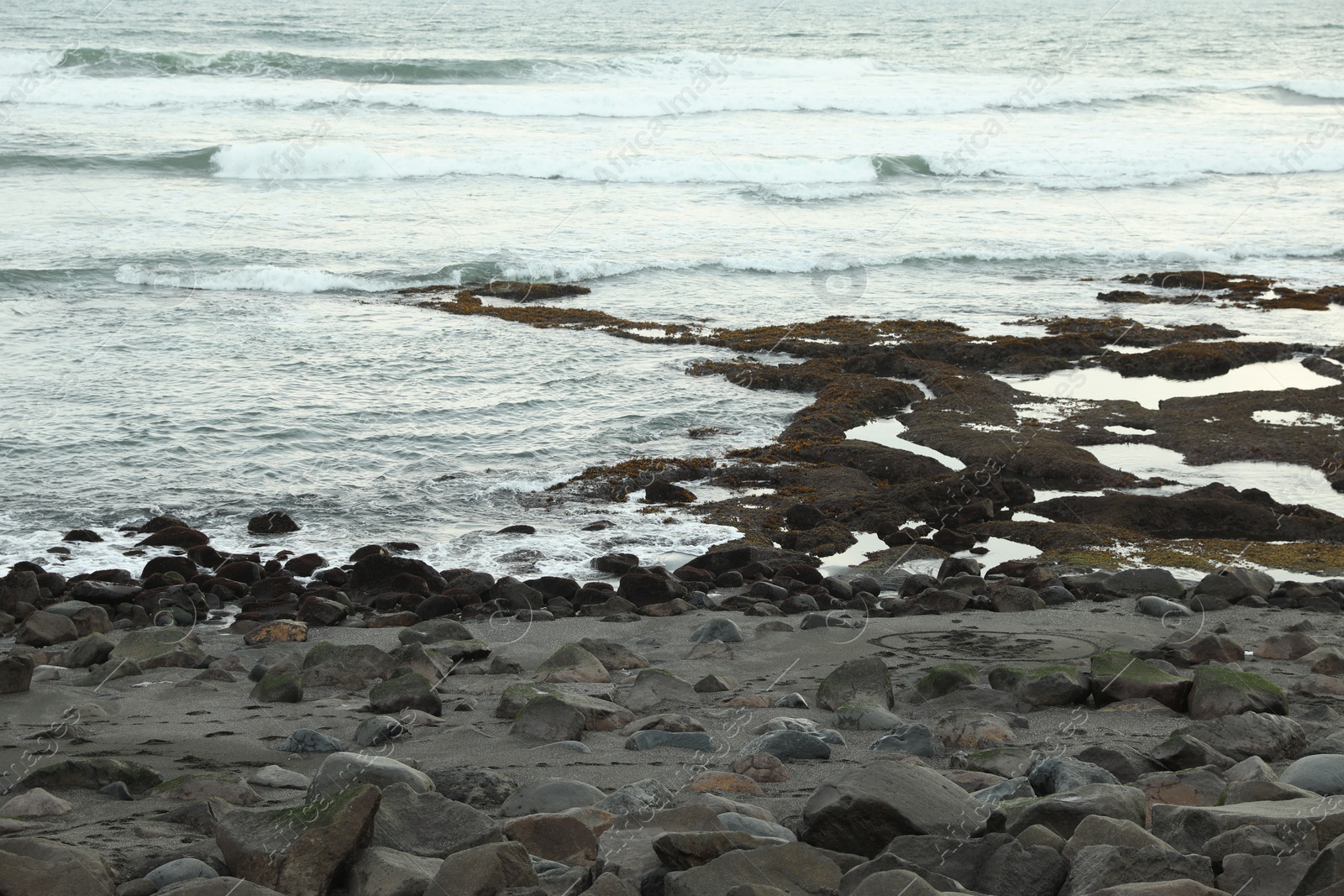 View of beautiful wavy sea and rocky beach, closeup Photo of View of beautiful wavy sea and rocky beach, closeup