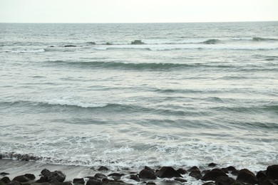 Photo of View of beautiful wavy sea and many stones