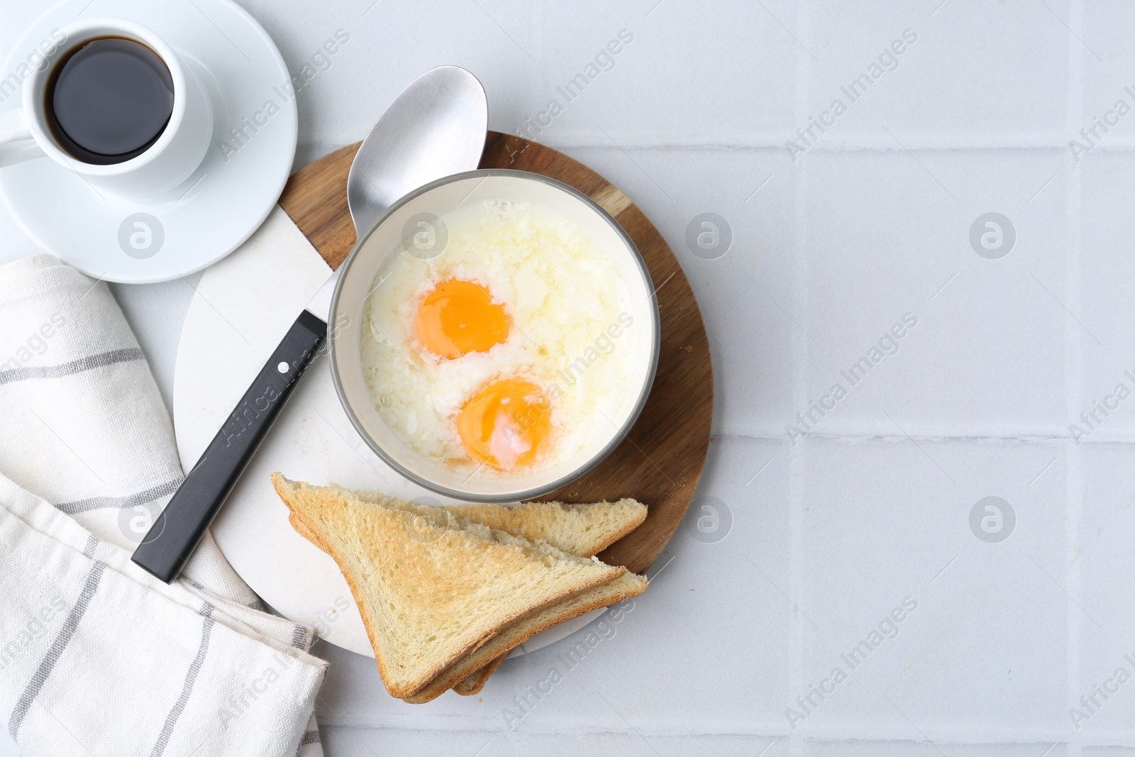 Half-boiled eggs in bowl, coffee and toasted bread on white tiled table, flat lay. Space for text Photo of Half-boiled eggs in bowl, coffee and toasted bread on white tiled table, flat lay. Space for text