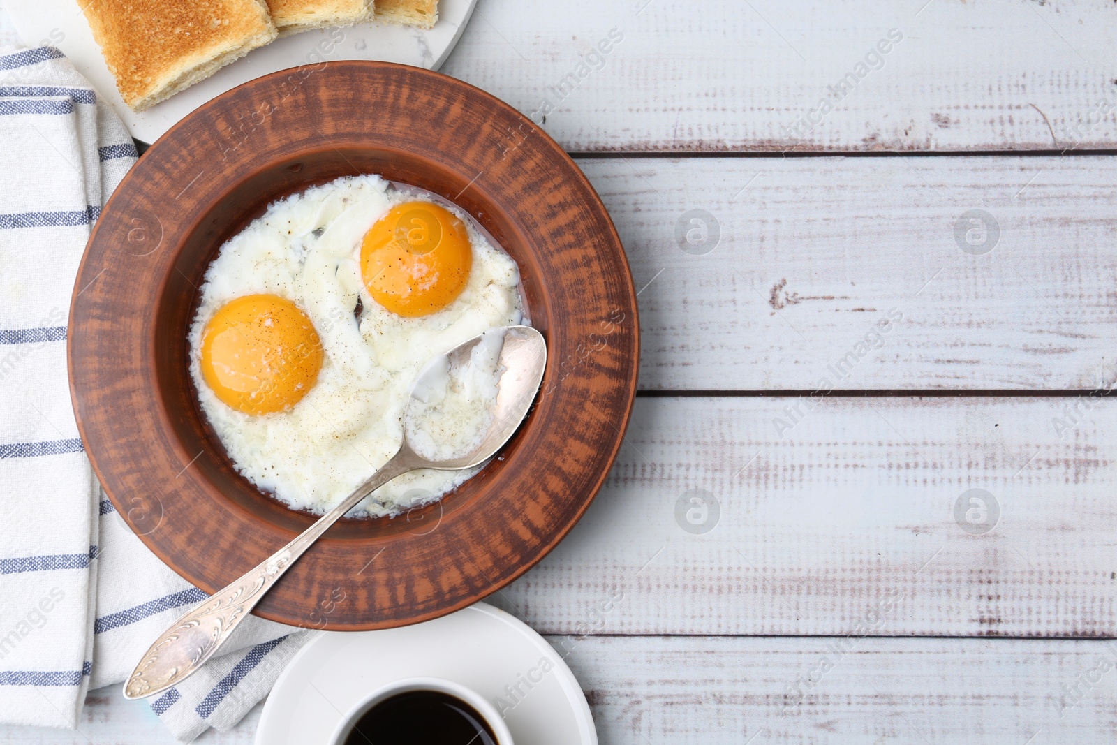 Half-boiled eggs in plate, coffee and toasted bread on white wooden table, flat lay. Space for text Photo of Half-boiled eggs in plate, coffee and toasted bread on white wooden table, flat lay. Space for text