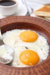 Photo of Half-boiled eggs in plate and spoon on table, closeup