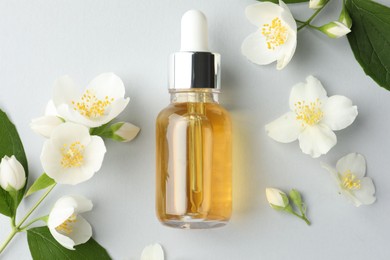 Photo of Cosmetic product and jasmine flowers on light background, flat lay