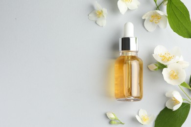 Photo of Cosmetic product and jasmine flowers on light background, flat lay. Space for text