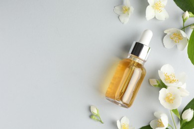 Photo of Cosmetic product and jasmine flowers on light background, flat lay. Space for text