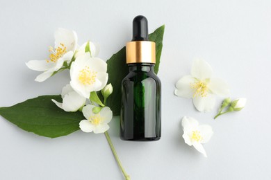 Photo of Cosmetic product and jasmine flowers on light background, flat lay