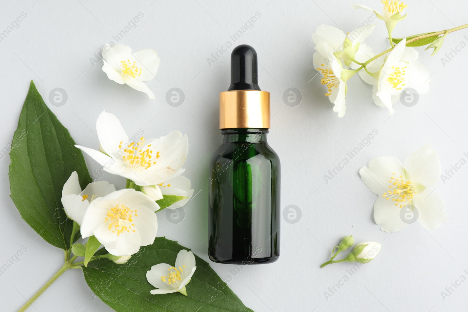Cosmetic product and jasmine flowers on light background, flat lay Photo of Cosmetic product and jasmine flowers on light background, flat lay
