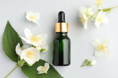 Photo of Cosmetic product and jasmine flowers on light background, flat lay