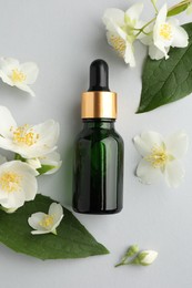 Photo of Cosmetic product and jasmine flowers on light background, flat lay