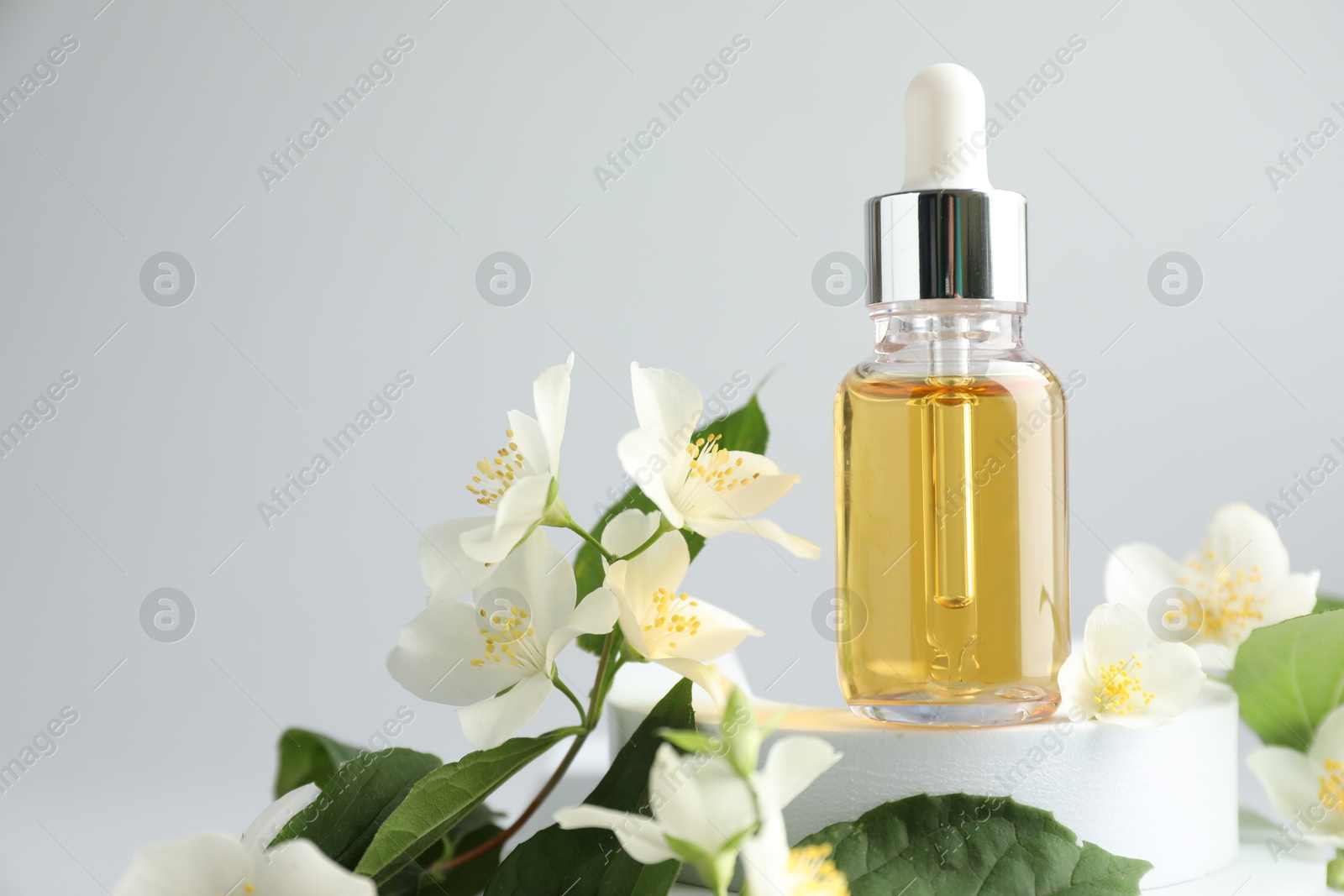 Cosmetic product and jasmine flowers on light background, closeup. Space for text Photo of Cosmetic product and jasmine flowers on light background, closeup. Space for text