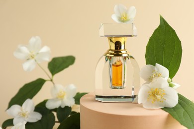 Photo of Bottle of perfume and jasmine flowers on beige background, closeup