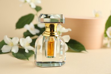 Photo of Bottle of perfume and jasmine flowers on beige background, closeup