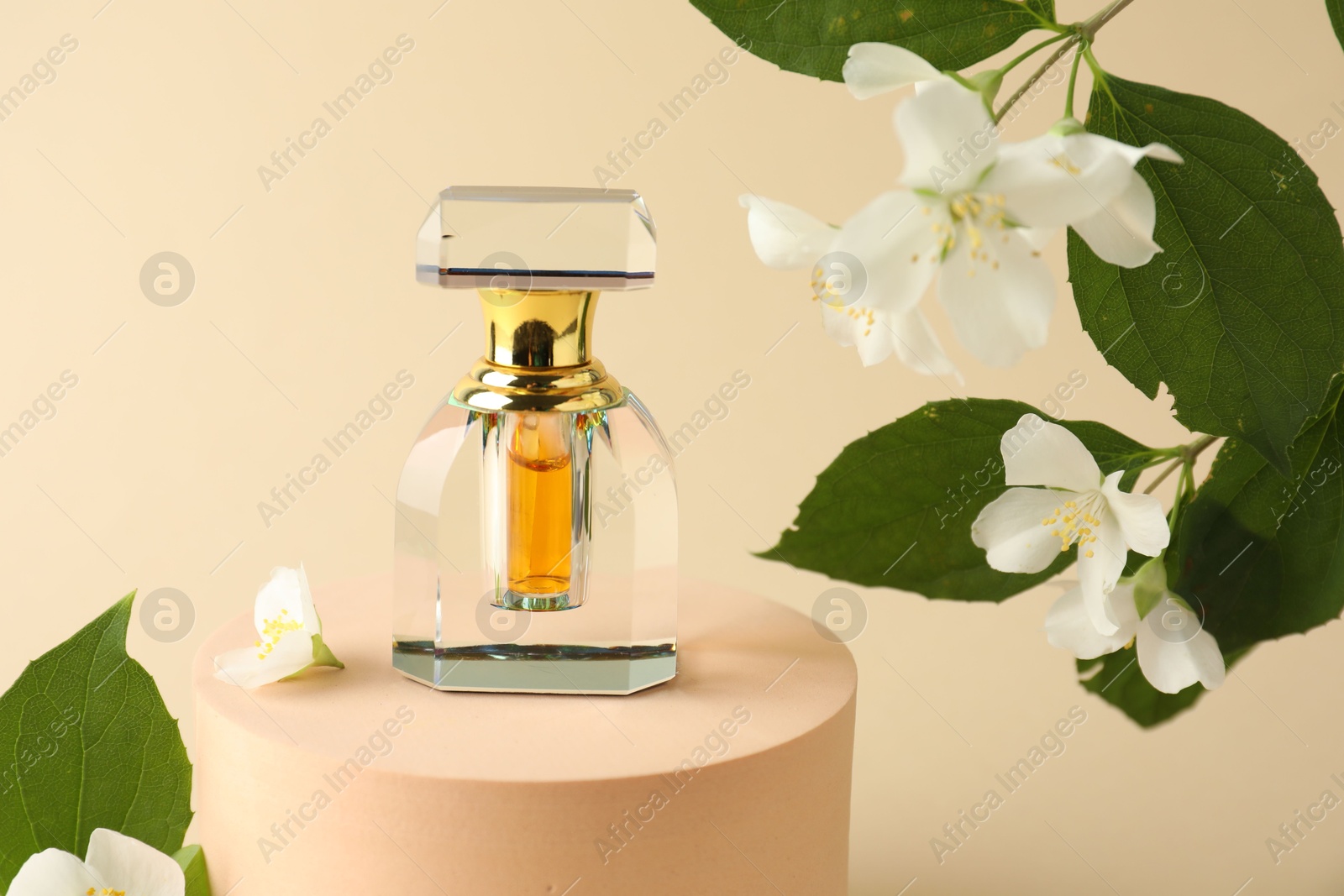 Bottle of perfume and jasmine flowers on beige background, closeup Photo of Bottle of perfume and jasmine flowers on beige background, closeup
