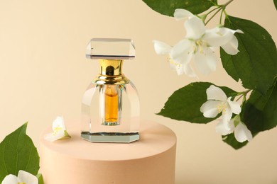 Photo of Bottle of perfume and jasmine flowers on beige background, closeup