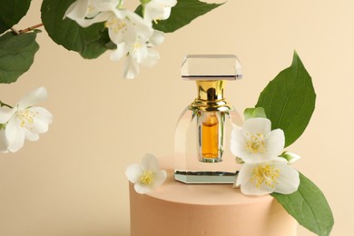 Photo of Bottle of perfume and jasmine flowers on beige background, closeup