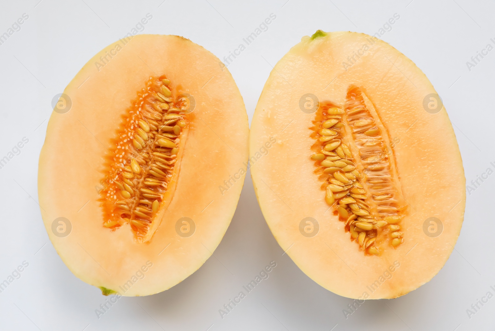 Halves of juicy melon on white background, top view Photo of Halves of juicy melon on white background, top view