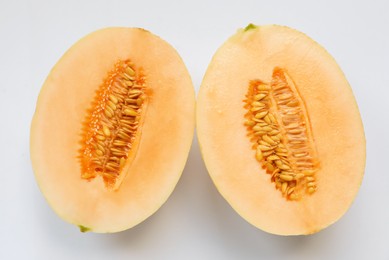 Photo of Halves of juicy melon on white background, top view