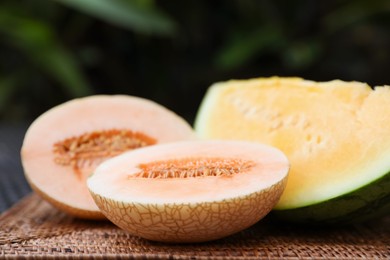 Photo of Ripe juicy tropical fruits on wicker table, closeup