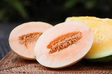 Photo of Ripe juicy tropical fruits on wicker table, closeup