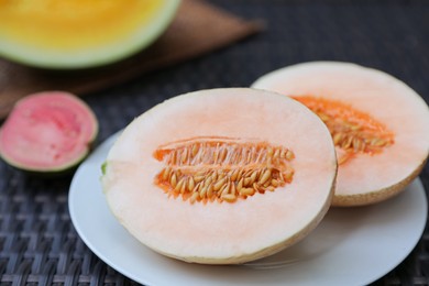 Photo of Ripe juicy tropical fruits on wicker table, closeup