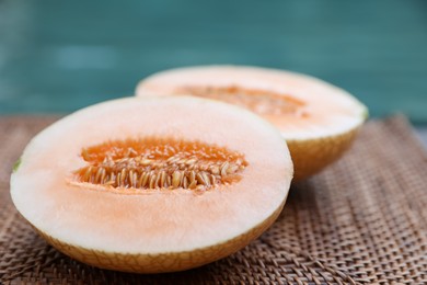 Photo of Halves of juicy melon on wicker tray near swimming pool, closeup