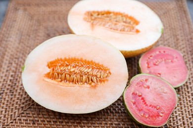 Photo of Ripe juicy tropical fruits on wicker tray, closeup