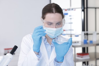 Photo of Scientist working with sample in Petri dish in laboratory