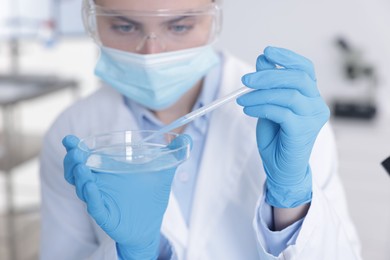 Photo of Scientist working with sample in Petri dish in laboratory, selective focus