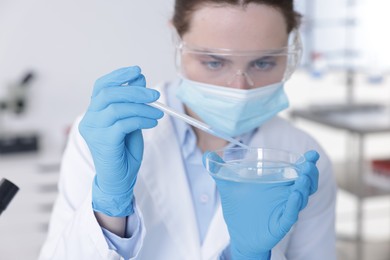 Photo of Scientist working with sample in Petri dish in laboratory, selective focus