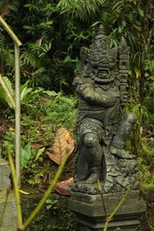 Photo of Bali, Indonesia - May 24, 2025: Beautiful Dvarapala statue and green plants outdoors