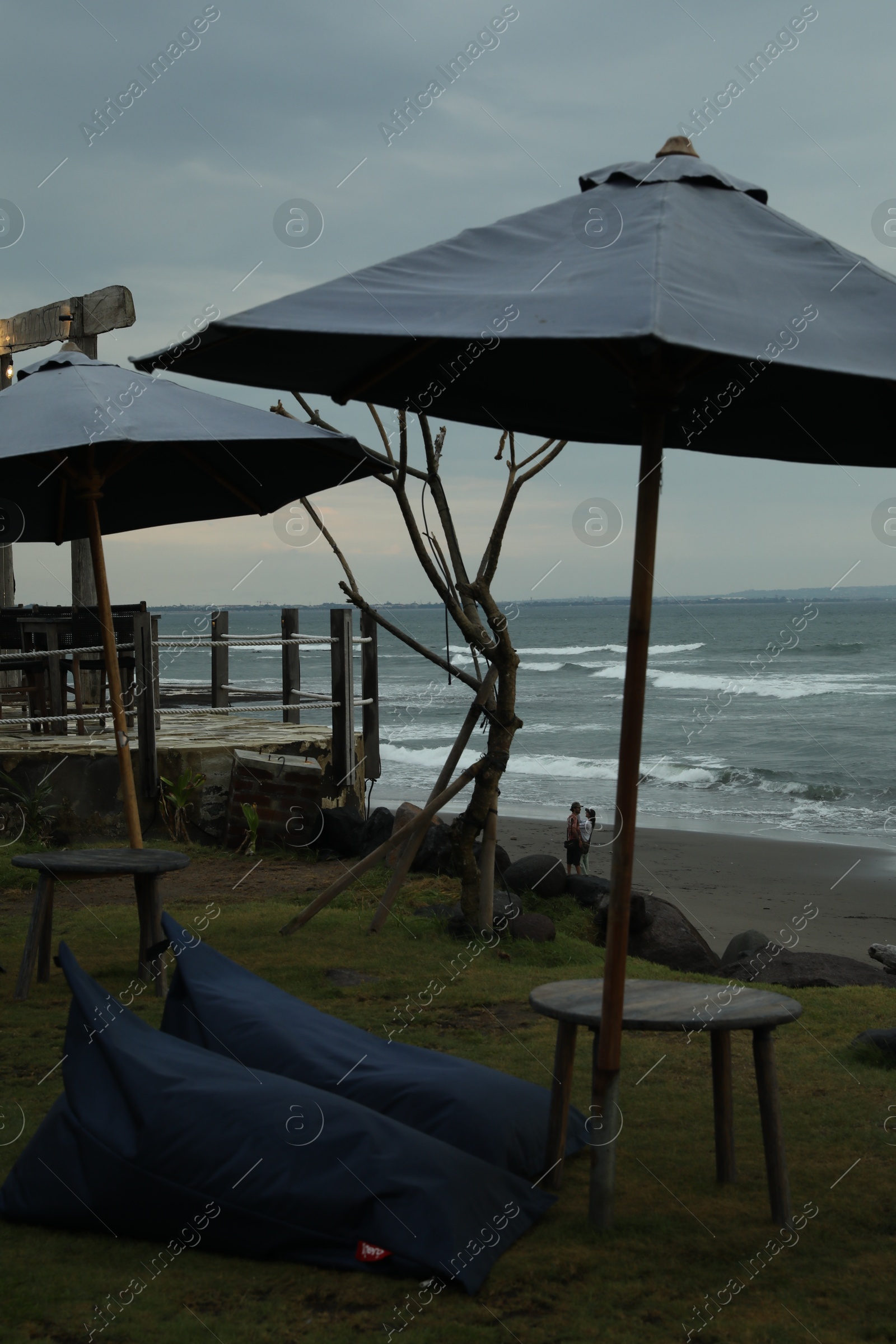 Bali, Indonesia - May 27, 2025: Bean bag chairs, tables and umbrellas on beach near sea Photo of Bali, Indonesia - May 27, 2025: Bean bag chairs, tables and umbrellas on beach near sea