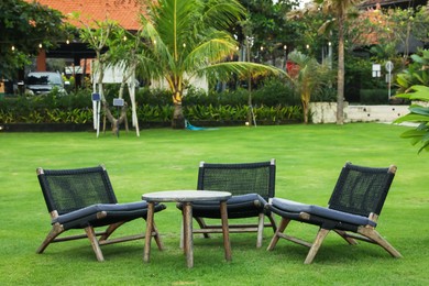 Photo of Chairs, table and different green plants outdoors