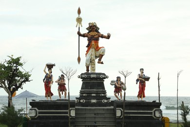 Photo of Bali, Indonesia - May 27, 2025: Different statues on beach near sea