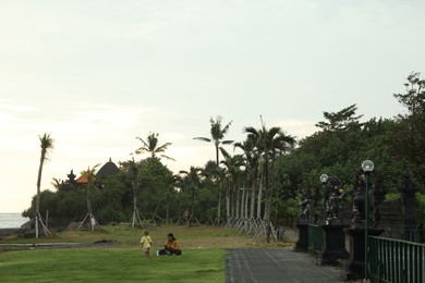 Photo of Bali, Indonesia - May 27, 2025: View of beautiful beach, people and green tropical forest