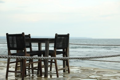Photo of Chairs and table on beach near sea