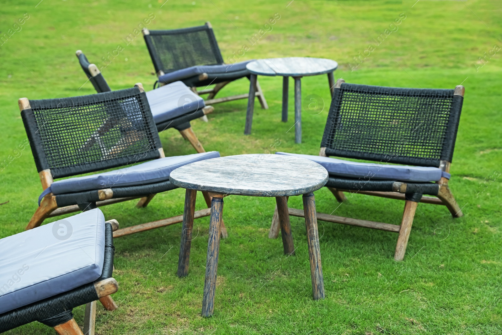Chairs and tables on green grass outdoors Photo of Chairs and tables on green grass outdoors