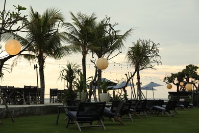 Photo of Bali, Indonesia - May 27, 2025: View of green palms and outdoor cafe