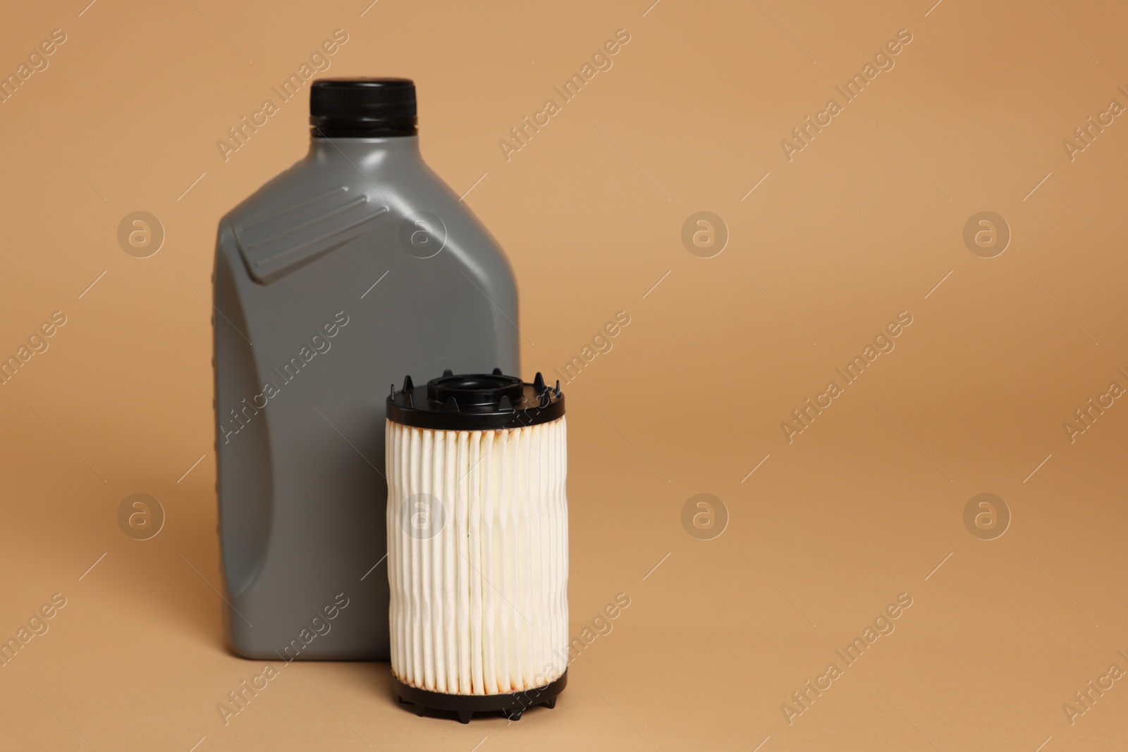 Motor oil in plastic canister and filter on beige background, space for text Photo of Motor oil in plastic canister and filter on beige background, space for text