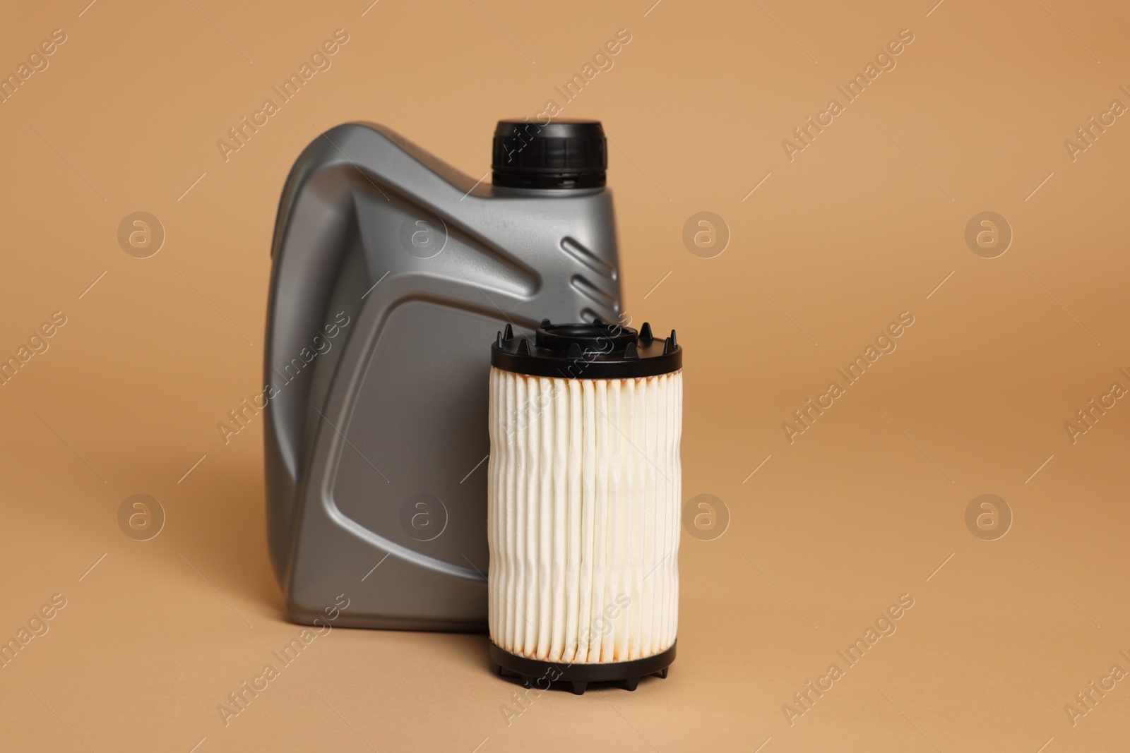 Motor oil in plastic canister and filter on beige background, space for text Photo of Motor oil in plastic canister and filter on beige background, space for text