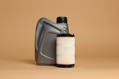 Photo of Motor oil in plastic canister and filter on beige background